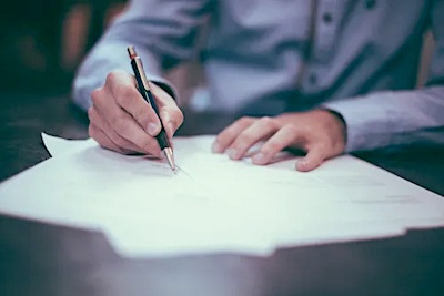 photo of man writing on paper